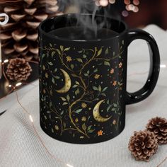 BPA and lead-free, microwave and dishwasher-safe, and made of black durable ceramic and available in 11-ounce and 15-ounce sizes. The high-quality sublimation printing makes this black ceramic mug the perfect gift for your true coffee, tea, or hot chocolate lover. 🗻 Unique Botanical Celestial design 🗻 Available in 11oz and 15oz sizes 🗻 Elegant black ceramic 🗻 Microwave safe for easy reheating 🗻 Dishwasher safe for effortless cleaning 🗻 Smooth rounded corners for a comfortable hold 🗻 Conve Celestial Ceramics, Witchy Mug, Celestial Ceramic Mug, Witchy Coffee Mugs, Night Sky Mugs, Cute Stars, Moon Design, Stars And Moon, Chocolate Lovers