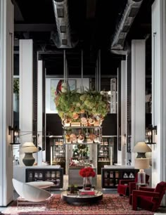 a living room filled with furniture and lots of plants on top of the tables in front of them