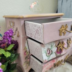 a pink dresser with floral designs on it