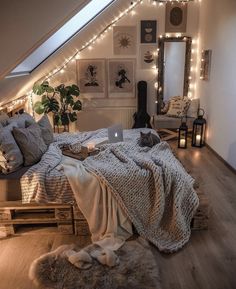 an attic bedroom with lights strung above the bed and rugs on the wooden floor