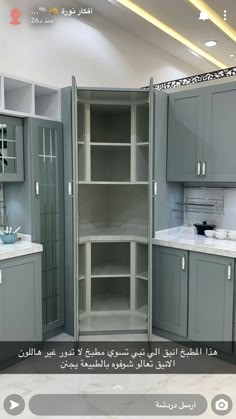 a kitchen with grey cabinets and white counter tops in arabic writing on the bottom right corner