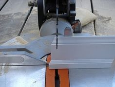 a machine that is sitting on top of a wooden floor next to a piece of metal