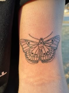 a small butterfly tattoo on the arm