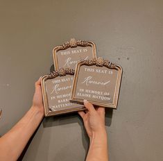 two people are holding up signs on the wall