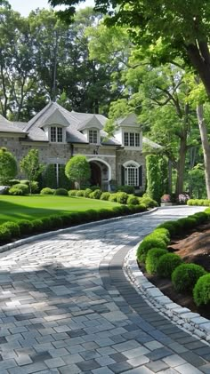 a stone driveway surrounded by lush green trees