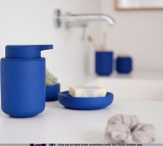 a bathroom counter with soap and toothbrushes in blue containers next to the sink