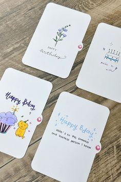 four coasters with different designs on them sitting on a wooden table together, one has a happy birthday message and the other has an elephant