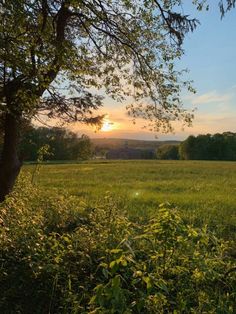 the sun is setting over an open field