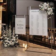 a couple of white flowers sitting on top of a table next to a sign that says your seat