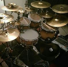 a bunch of drums sitting on top of a drum set in front of a mirror