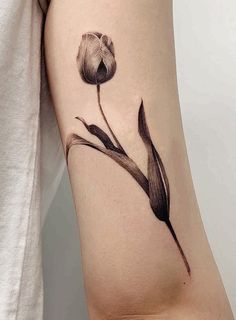 a black and white flower tattoo on the arm