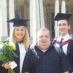 three people in graduation gowns posing for a photo