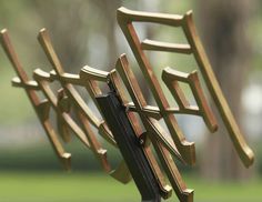 three wooden chairs sitting next to each other on top of a grass covered park bench