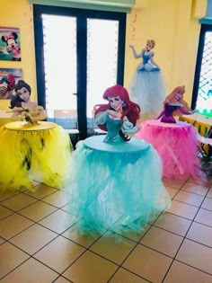 there are many different colored tables in the room with little mermaids on them,