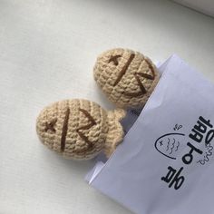 two small crocheted cookies sitting on top of a piece of paper next to each other