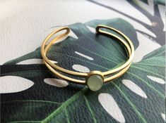 A piece of stylish & modern look gold bangle, which is made with genuine 100% natural real light green Chinese jade bead and 14k gold plated 925 sterling silver bracelet. A great combination of charm and elegance. The minimalistic design is great for your daily wear or special occasions. Perfect as a gift for your loved ones or just as a treat yourself :) Some Highlights of this gold jade bead cuff are: ＊High-quality Material Only 100% natural green jades paired with solid 925 sterling silve Gold Jade Bangle Bracelet, Modern Green Cuff Bangle Bracelet, Modern Yellow Gold Jade Jewelry, Modern Jade Gemstone Jewelry, Gold Jade Bangle, Modern Green Bangle Jewelry, Minimalist Gold Jade Jewelry, Modern Gold Jade Jewelry, Elegant Jade Bangle