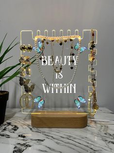 a display case with jewelry on it that says beauty is within and surrounded by butterflies