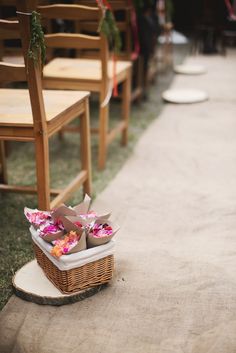 a basket filled with flowers sitting on top of a wooden chair