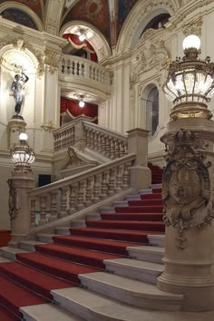 an ornate staircase in a building with red carpet