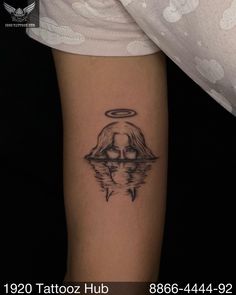 a woman's arm with a tattoo on it and an angel above her head