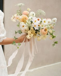 a woman holding a bouquet of flowers in her hand