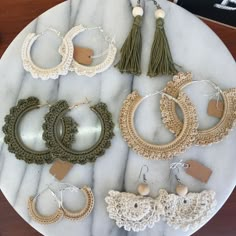 a marble table topped with lots of different types of hoops and tassels