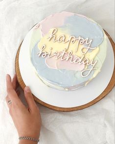 a cake with the words happy birthday on it being held by a woman's hand