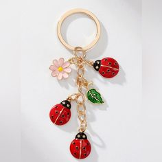 a ladybug keychain with four charms attached to it