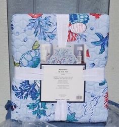 a blue and white quilted blanket with an image of sea life on the back