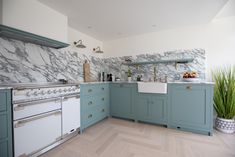 a kitchen with blue cabinets and marble counter tops