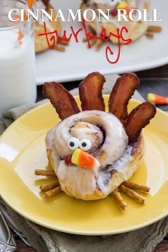 a yellow plate topped with a donut covered in bacon and a turkey face made out of doughnuts