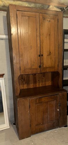 an old wooden cabinet with two doors and shelves