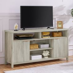 a flat screen tv sitting on top of a wooden entertainment center