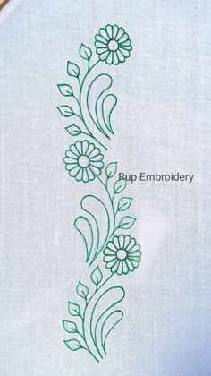 the embroidery is stitched on top of a white piece of cloth with green thread