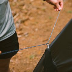 a person pulling something out of the back of a tent with a rope attached to it