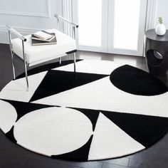 a black and white area rug with circles on the floor in front of a window