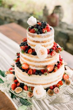 a three tiered cake with fresh fruit on top