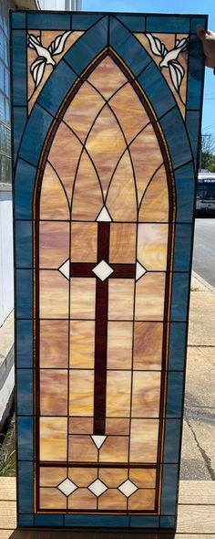 a stained glass window with a cross on the front and side panels in different colors