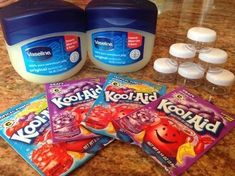 three containers of yogurt and four packets of koola - aid on a counter