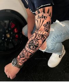 a man with a tattoo on his arm is sitting in front of a tire wheel