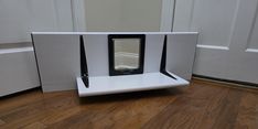 an electronic device sitting on top of a white shelf in front of a door,