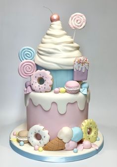 there is a cake decorated with donuts and other sweets on the top of it