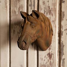 a wooden horse head mounted to the side of a wall