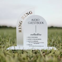 a white plaque sitting on top of a lush green field