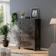 a living room scene with focus on the dresser and potted plant in the corner