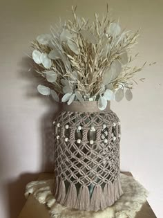 a crocheted vase with white flowers in it