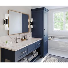 a bathroom with blue cabinets and marble counter tops, along with a white bathtub