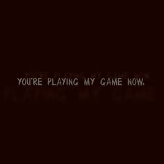 the words you're playing my game now are written in black on a dark background