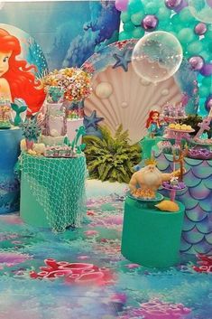 the little mermaid birthday party is set up in blue and green colors with balloons, decorations, and other items