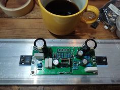 the electronic board is sitting next to a cup of coffee